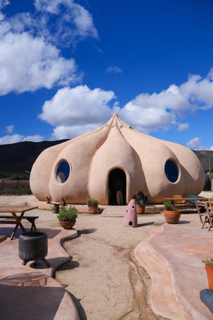 Garlic-shaped BloodLust Winebar under a bright blue sky