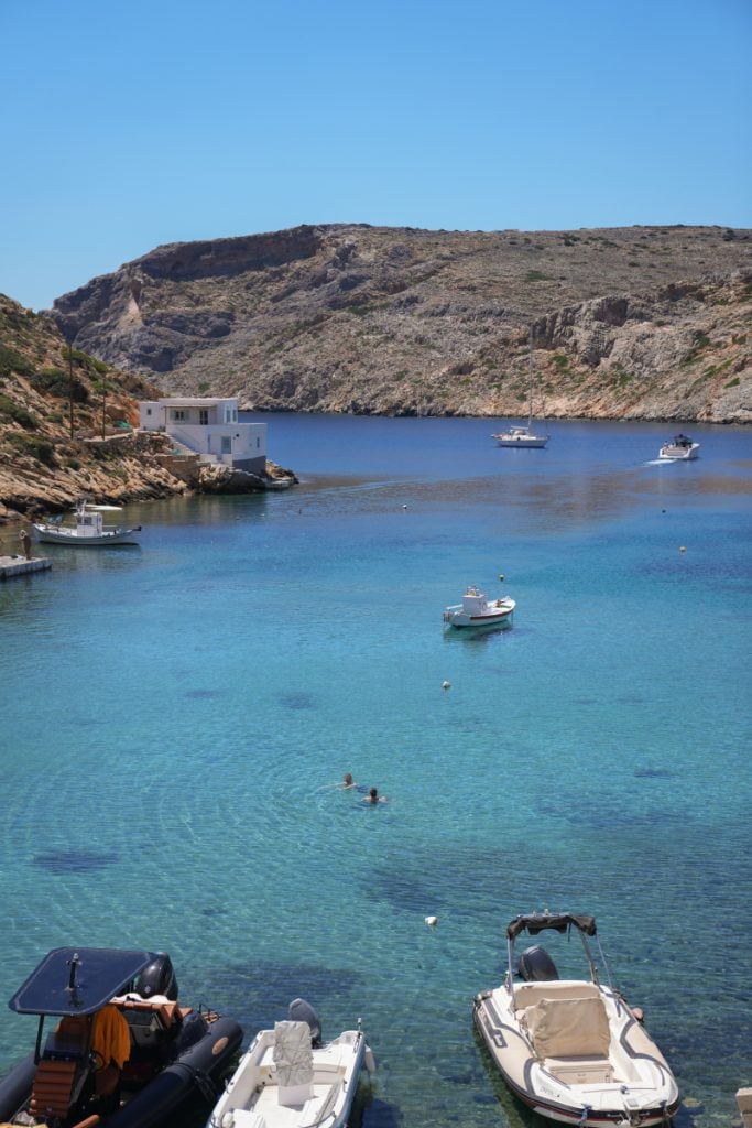 Small boats anchored in clear waters at Cheronissos Beach