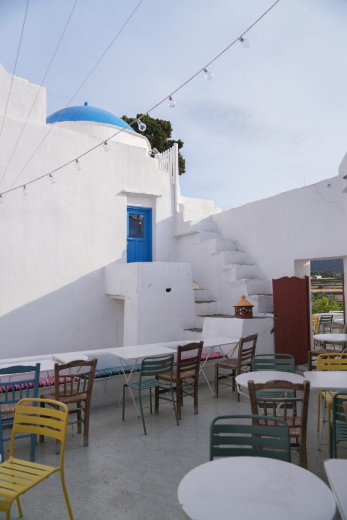 Cafe Mosaic courtyard with white walls and colorful chairs