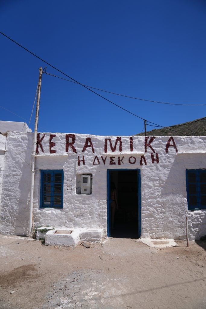 Whitewashed ceramics shop with blue trim in Cheronissos