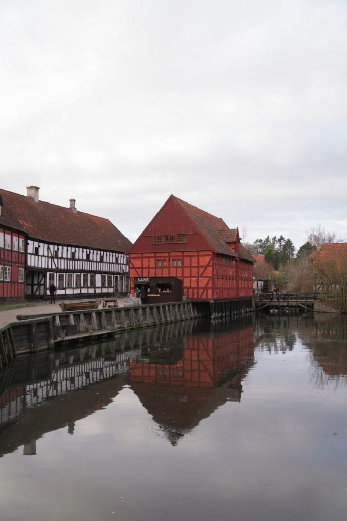 Half-timbered buildings reflected in Den Gamle By canal