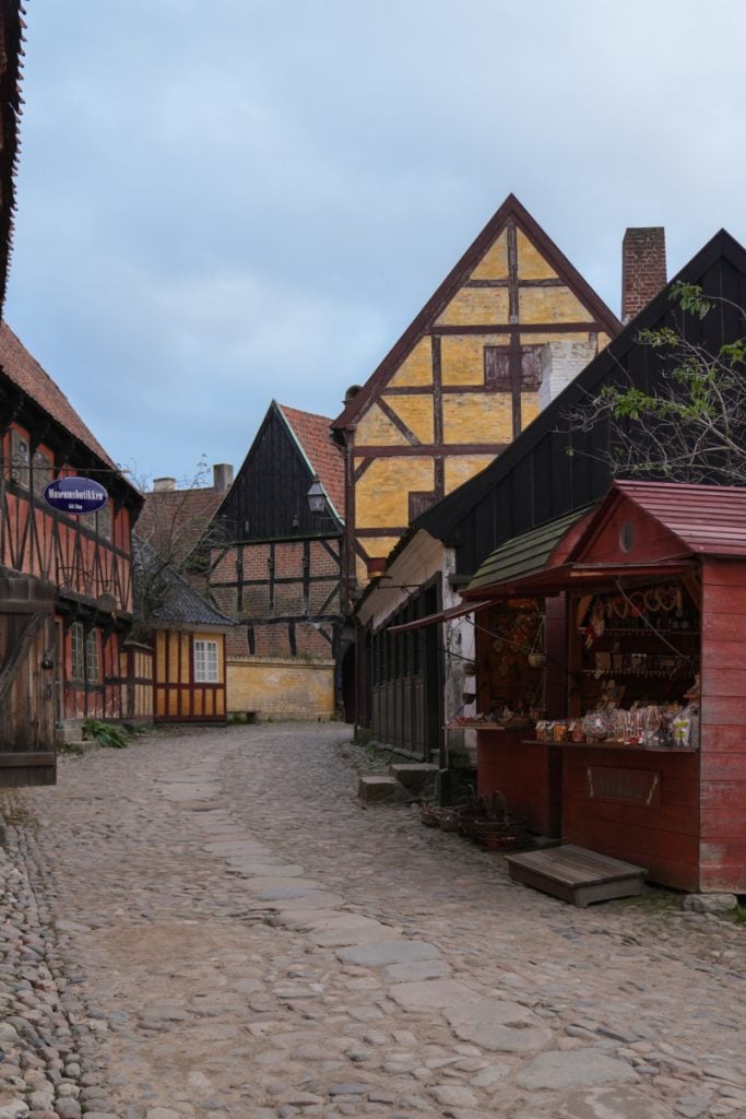 Market stall along a cobblestone lane in Den Gamle By