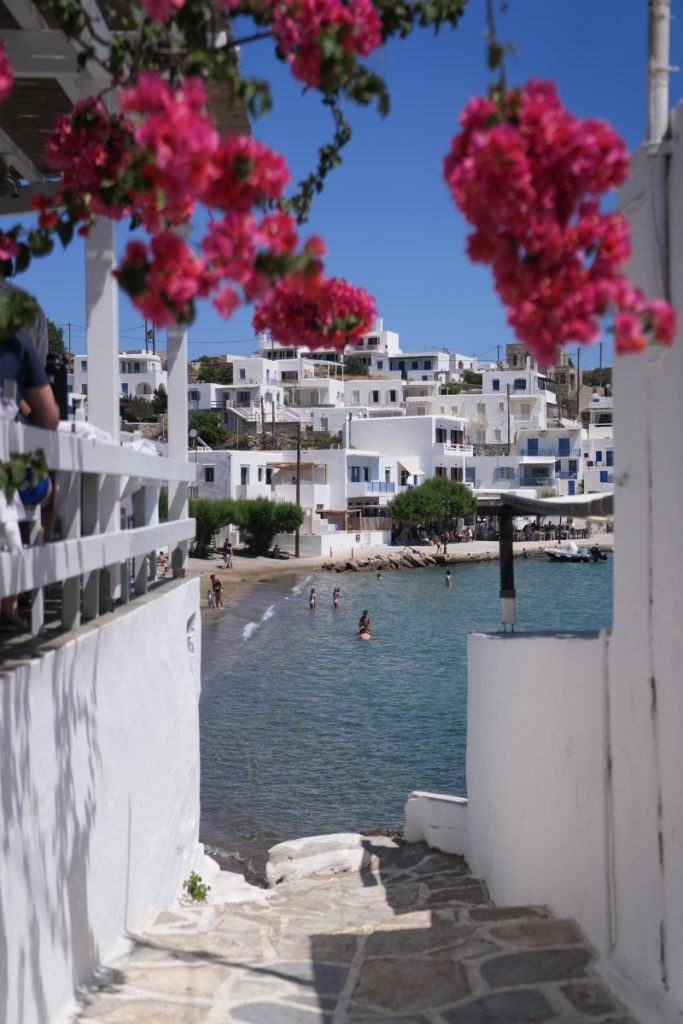 Stone steps framed by pink bougainvillea lead down to the waterfront in Faros.