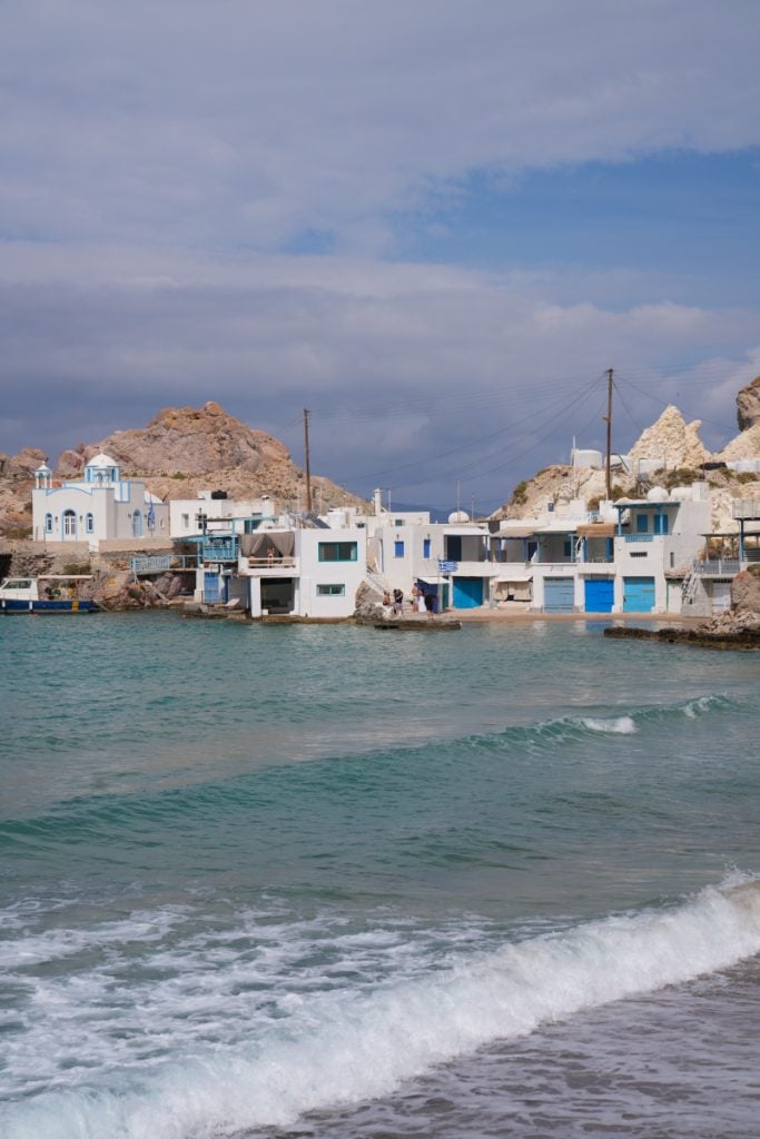 Waves rolling toward waterfront boathouses in Firopotamos
