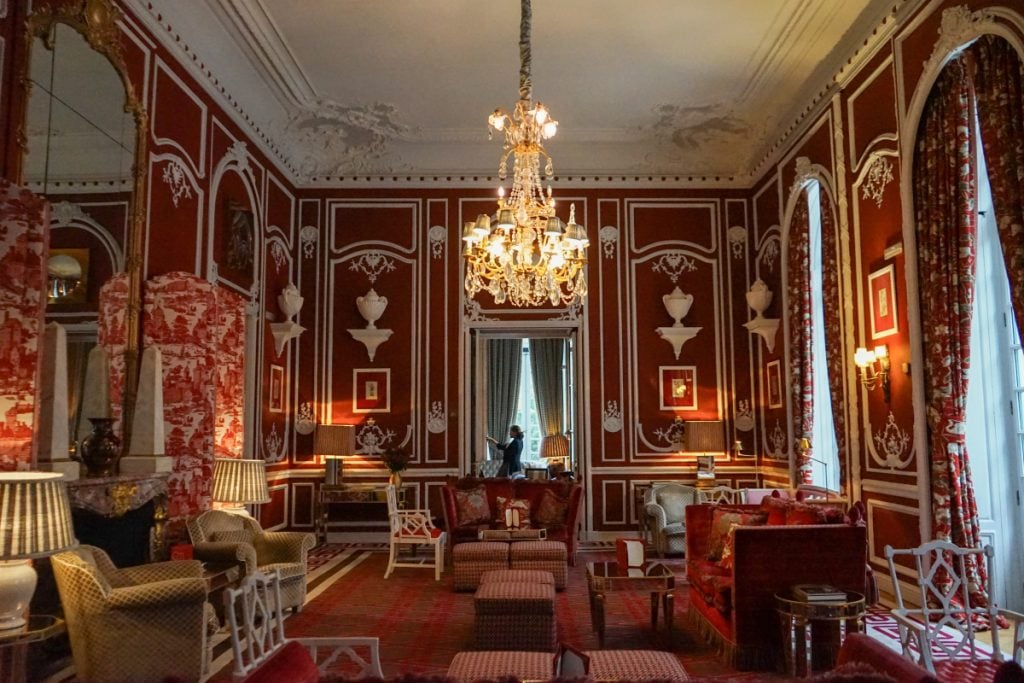 Red-walled lounge with a chandelier at Hotel Santo Mauro