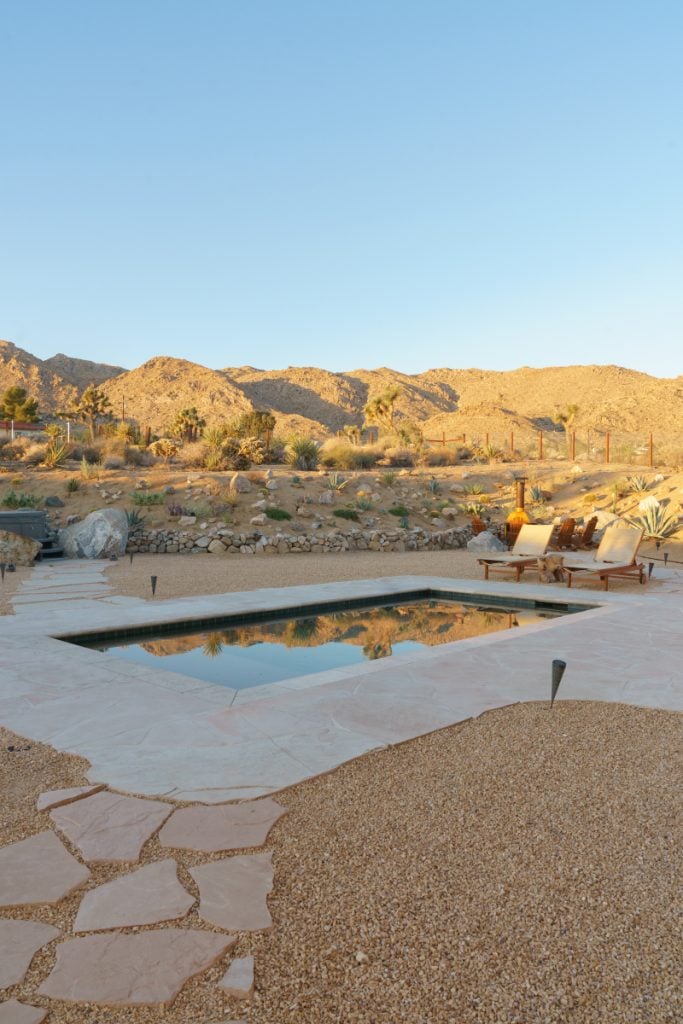 Desert Wild Home pool and loungers overlooking rocky desert hills