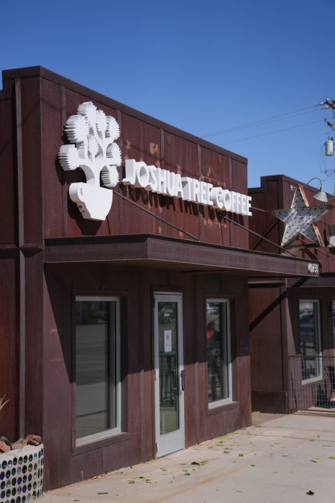 Joshua Tree Coffee storefront with its white sign and Joshua tree logo