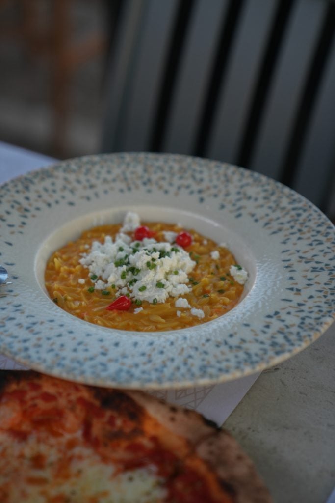 Orzo with crumbled feta beside pizza at Kyra
