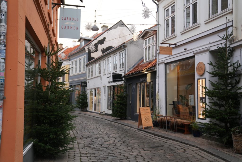 Shops and Christmas trees along a Latin Quarter cobblestone lane