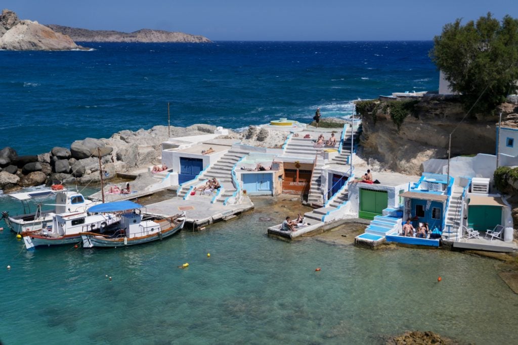 Fishing boats and colorful boathouses in Mandrakia cove