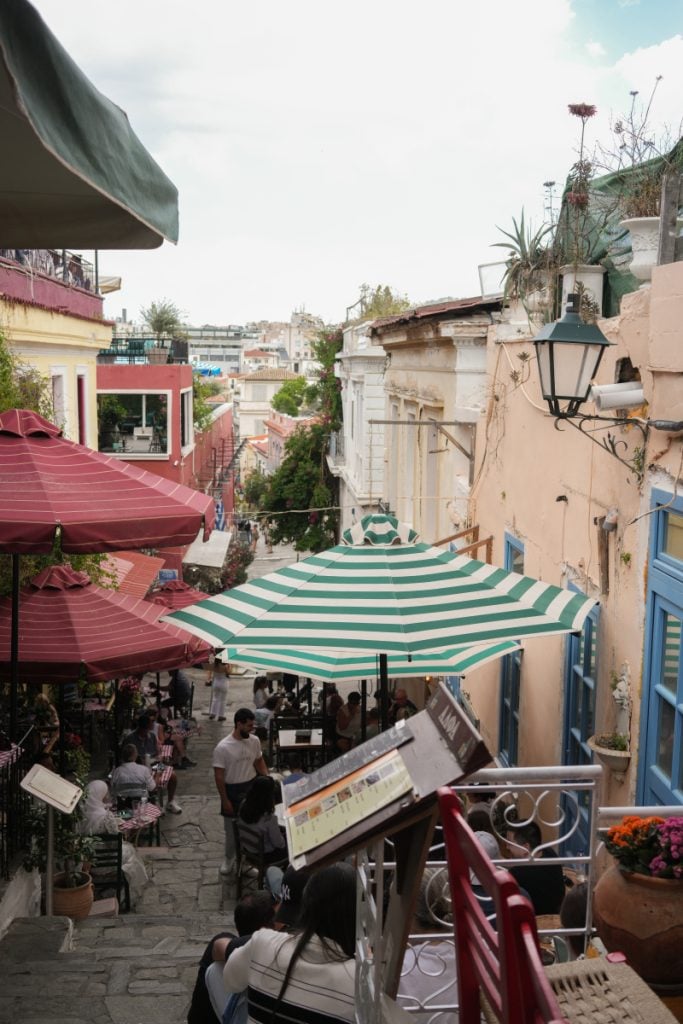 Outdoor cafés line the Mnisikleous Stairs