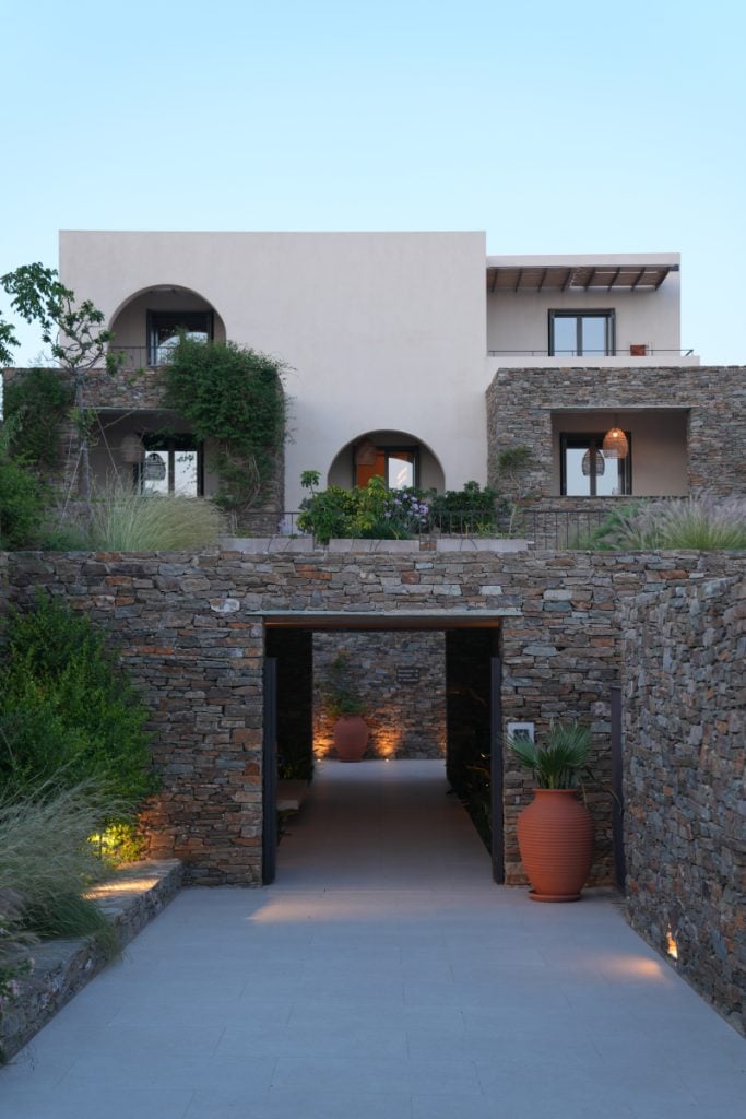 Stone-lined entrance and landscaped courtyard at NOS Hotel.