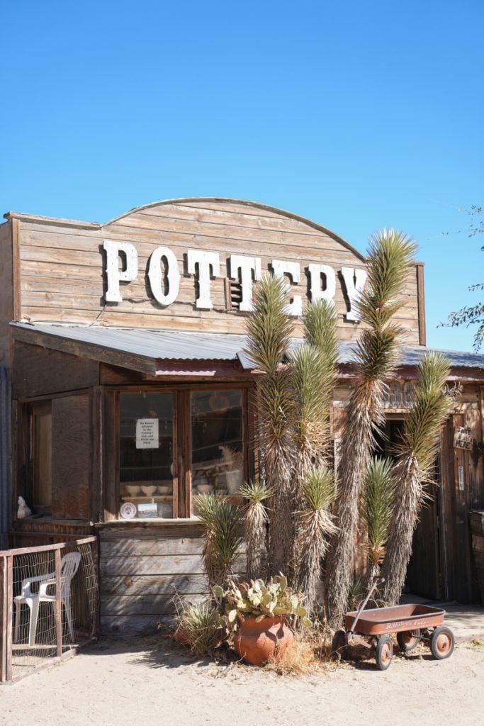 Wooden pottery shop with desert plants and a small wagon in Pioneertown