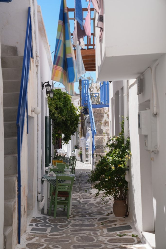 Café tables in a narrow whitewashed Plaka alley