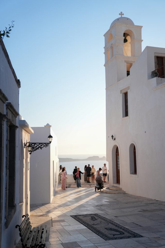 Church bell tower and visitors in Plaka at sunset
