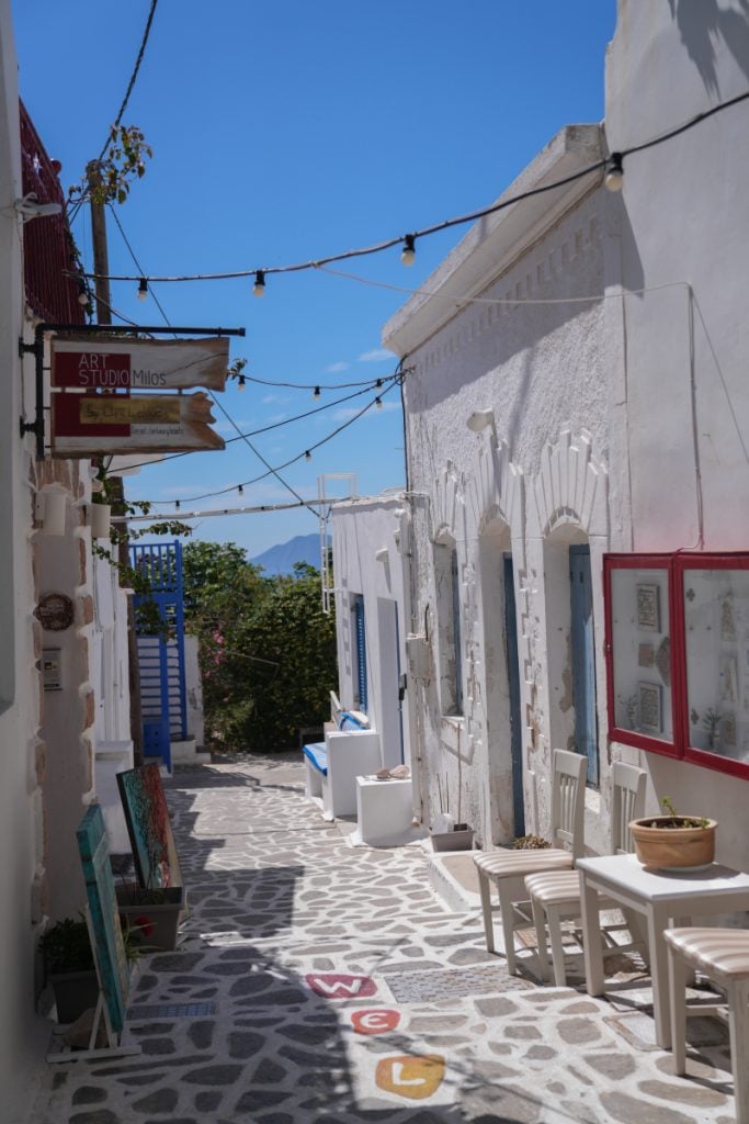 Shops and chairs along a whitewashed Plaka alley