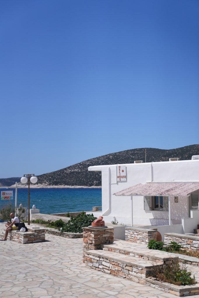 Seafront walkway beside white buildings in Platis Gialos.