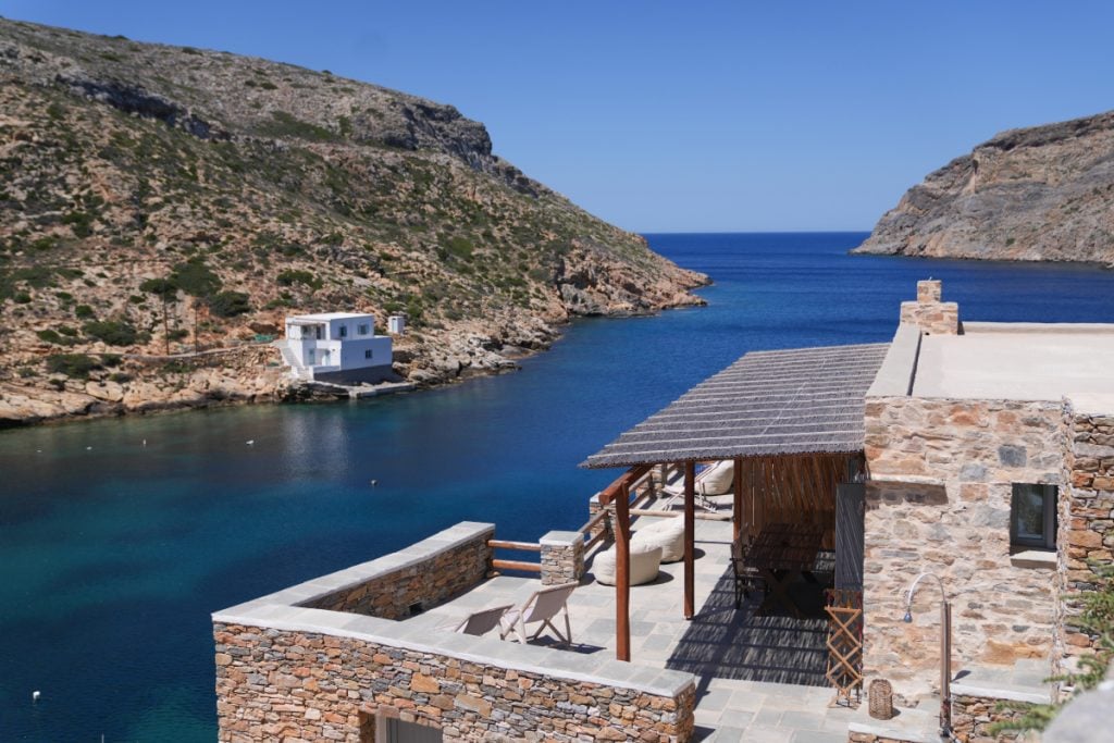 Stone terrace at a Psarona Hospitality home overlooking the Cheronissos inlet.