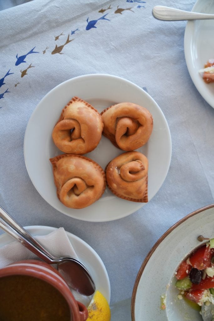 Four golden pastries on a white plate