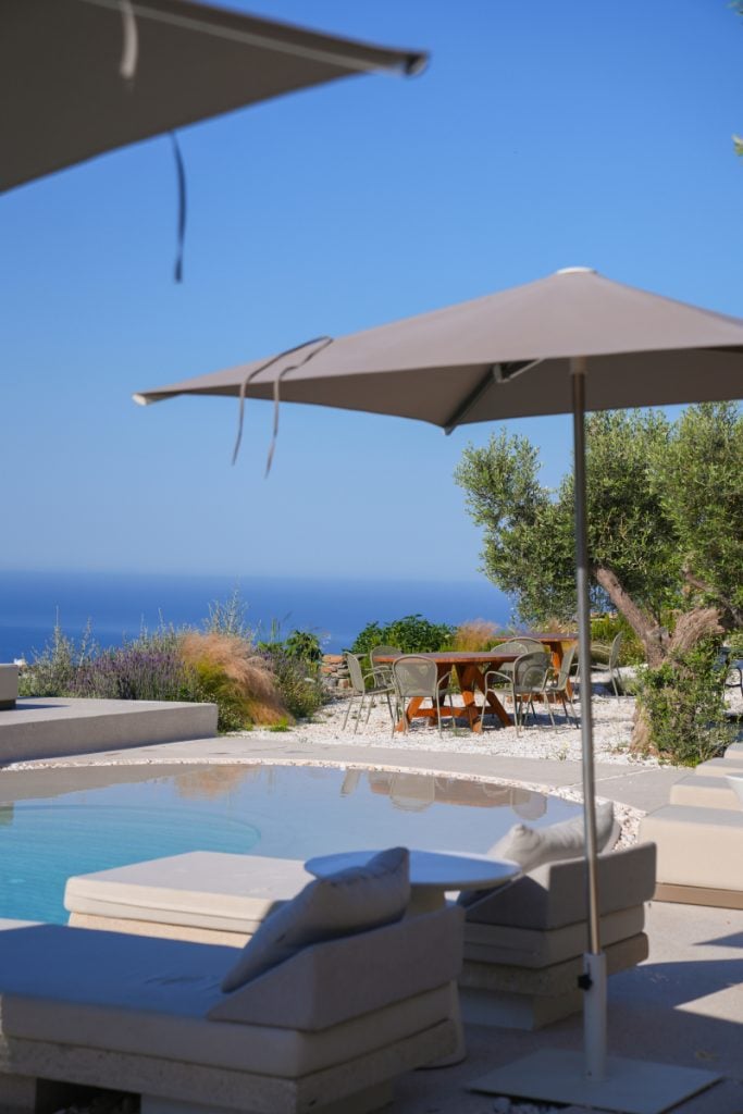 Poolside loungers and parasols overlooking the sea at Stamna Hotel.