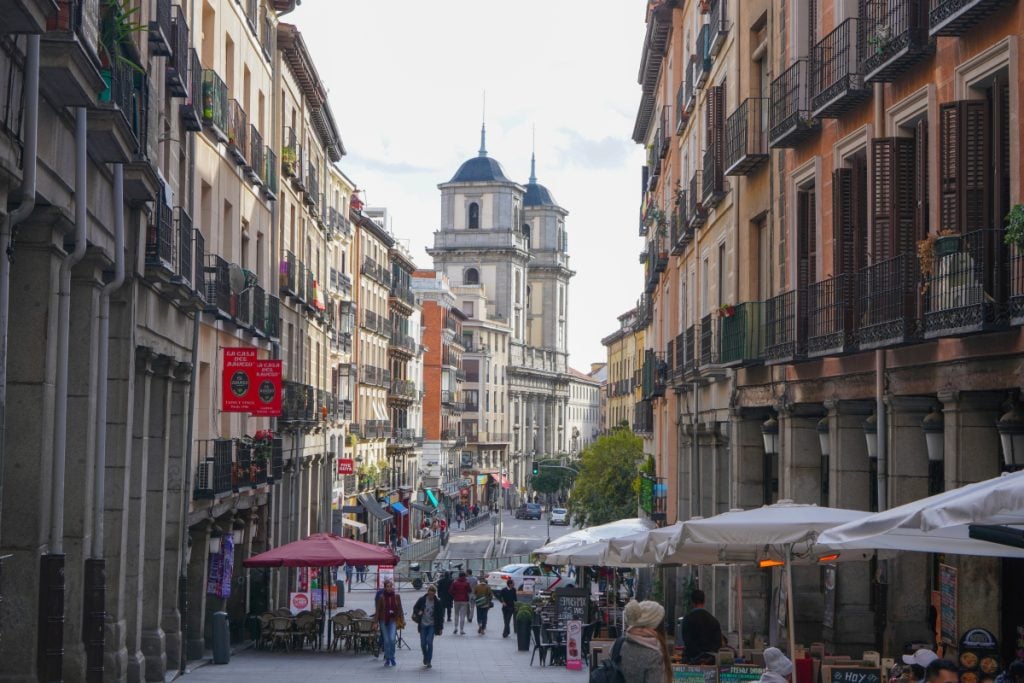 Central Madrid street lined with balconies and café terraces