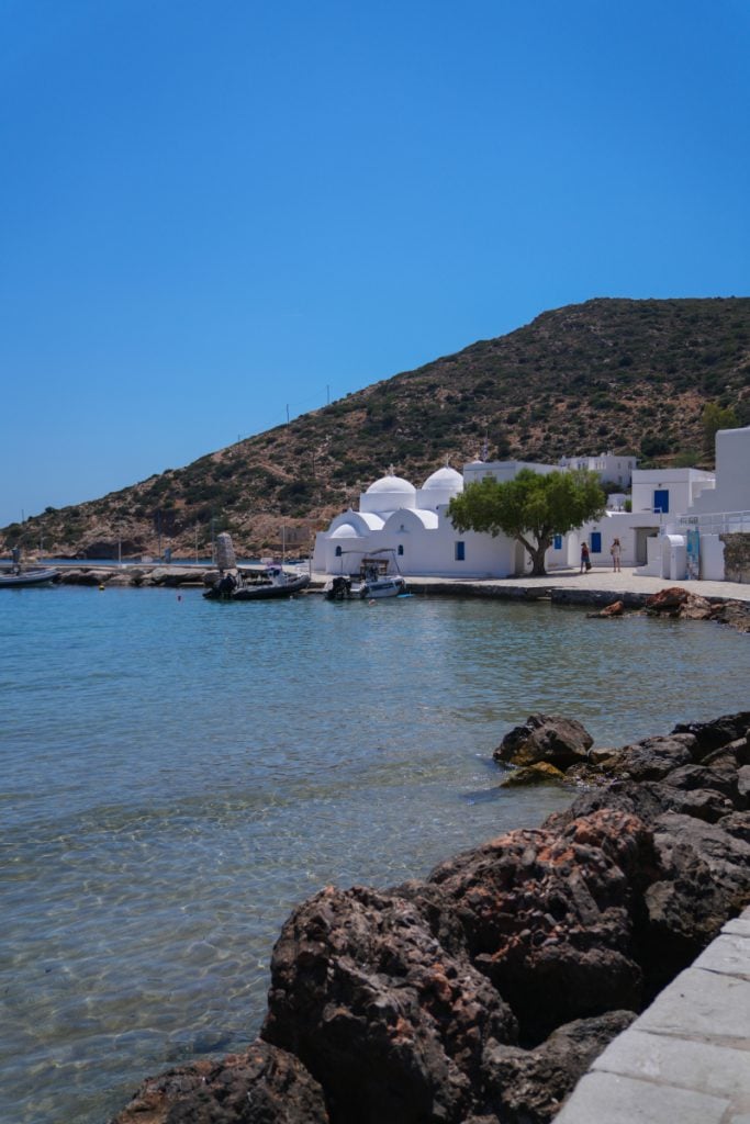 White waterfront church beside the clear blue water in Vathi.