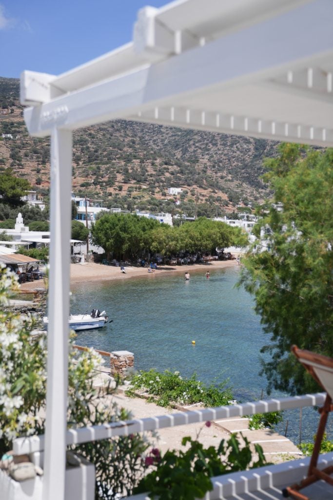 View through a white pergola toward Vathi beach and the waterfront.
