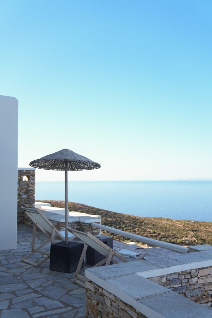 Sun loungers beneath a woven parasol overlooking the sea at Verina Astra.