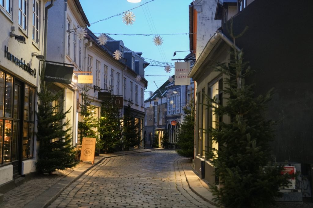 Christmas trees and lights along an Aarhus cobblestone street