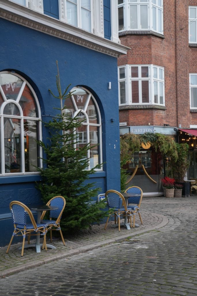 Outdoor café tables beside a blue building in Aarhus’s Latin Quarter