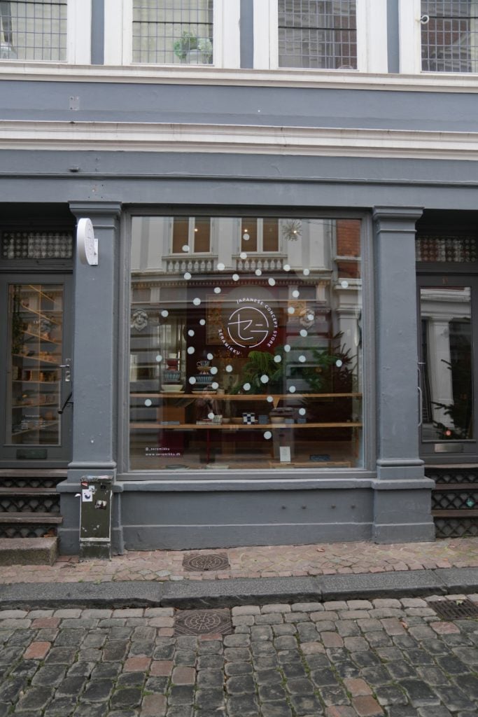 Gray shopfront with white-dot decals across its display window