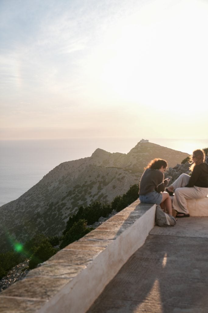 Visitors watch the sunset from Agios Symeon