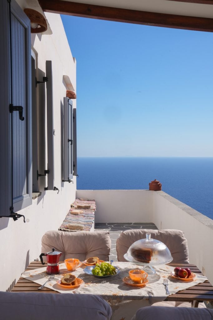 Breakfast table on a terrace overlooking the Aegean Sea