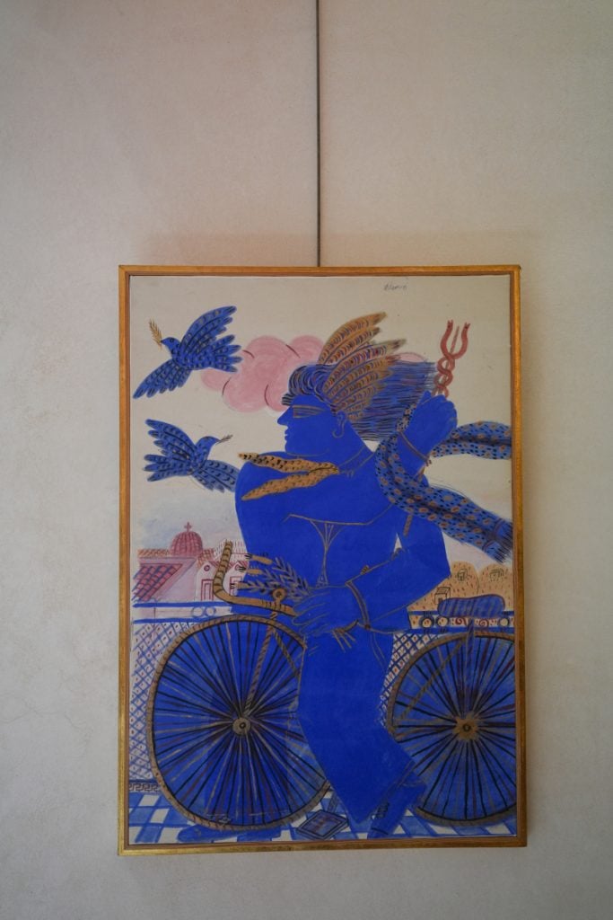 Framed artwork of a blue figure with bicycle and birds