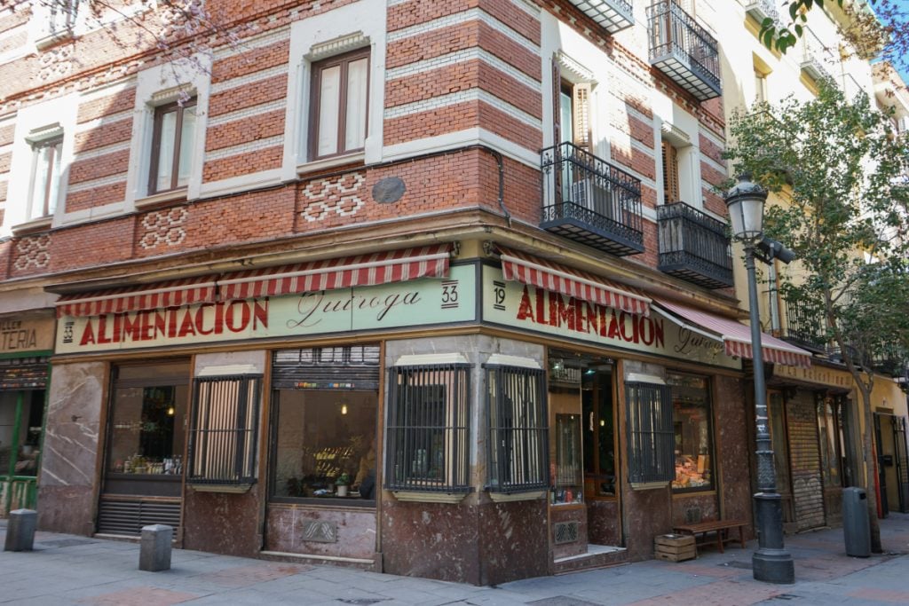 Alimentación Quiroga corner storefront with striped awnings