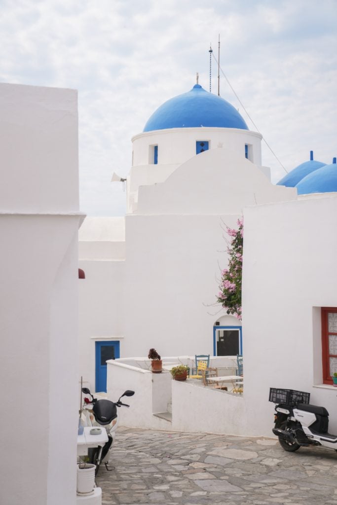 Blue-domed church above a whitewashed lane in Artemonas