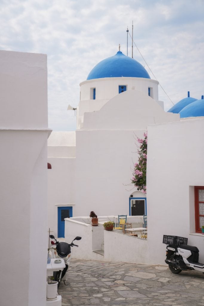 Blue-domed church above a whitewashed lane in Artemonas.