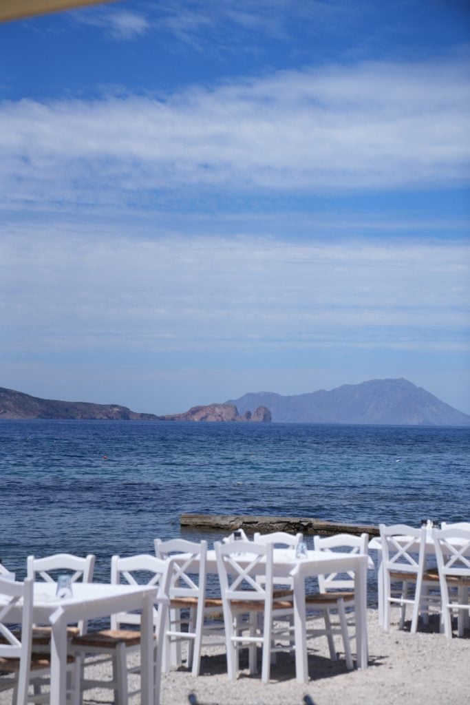 Seaside tables at Astakas with distant island views