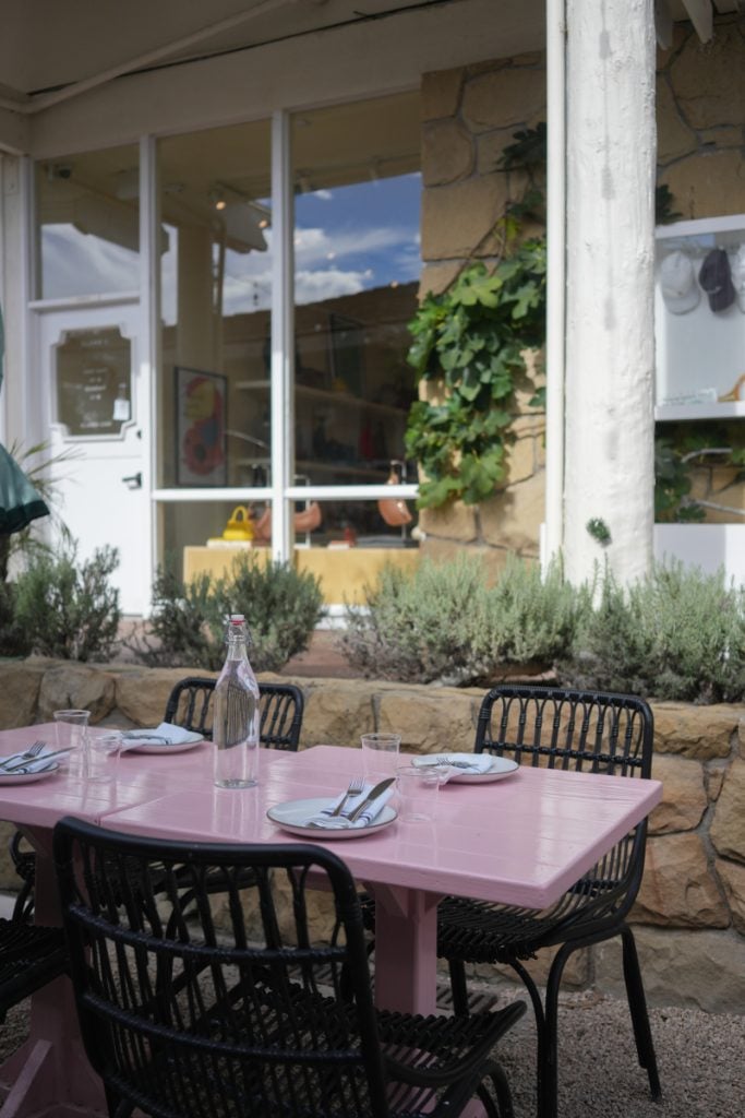 Pink outdoor dining table set with plates and glasses at Bettina