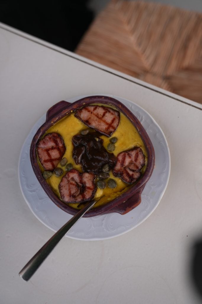 Yellow puree with grilled slices, capers, and dark relish
