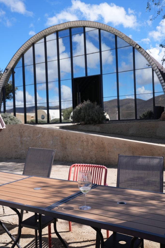 Duoma Vinos patio beneath an arched glass facade