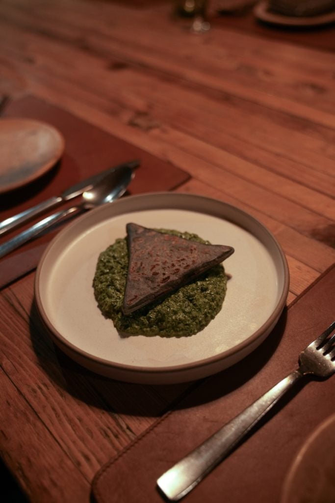 Triangular dish over green sauce at Fauna