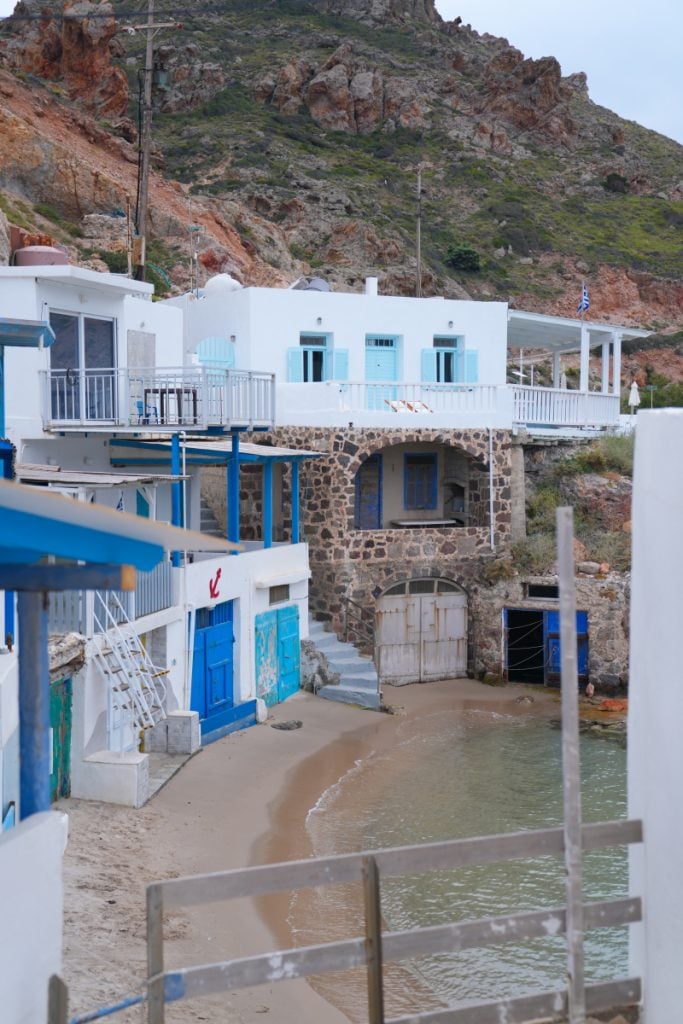 Whitewashed boathouses beside a small Firopotamos beach