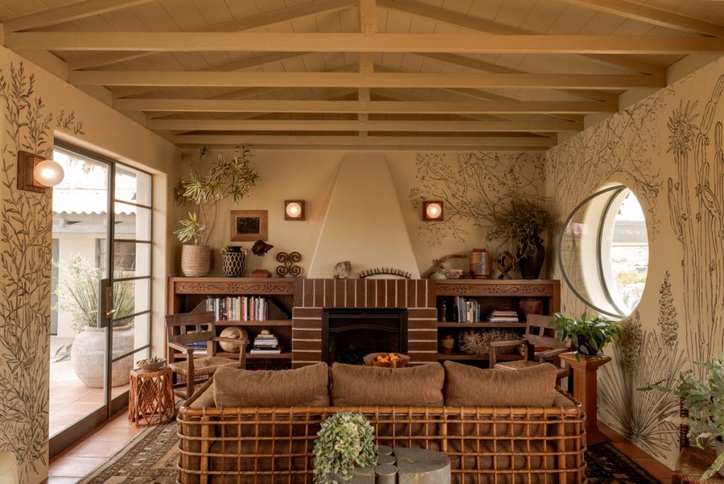 Hotel Wren lobby with woven seating, a fireplace and botanical wall murals