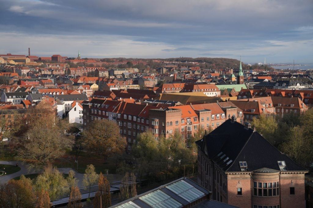 Aarhus rooftops and church spires beneath cloudy skies