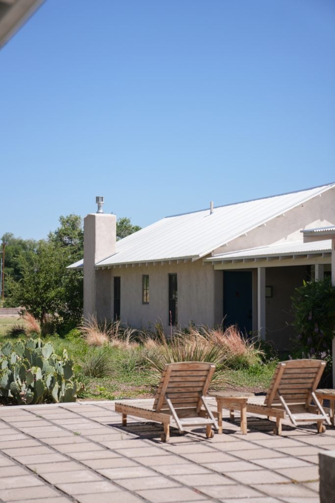 Patio loungers outside a stucco Los Poblanos building
