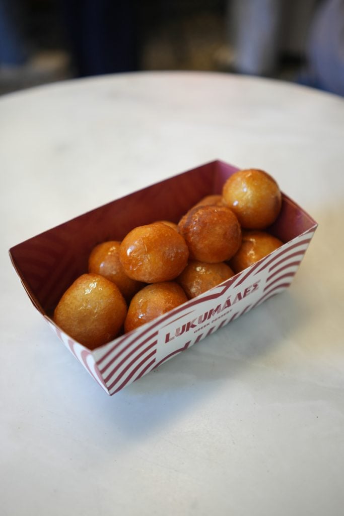 Glazed loukoumades in a paper tray