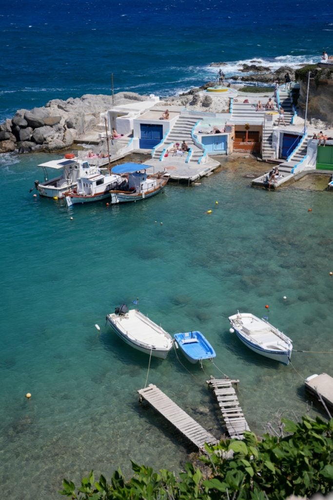 Boats moored beside Mandrakia's waterfront boathouses