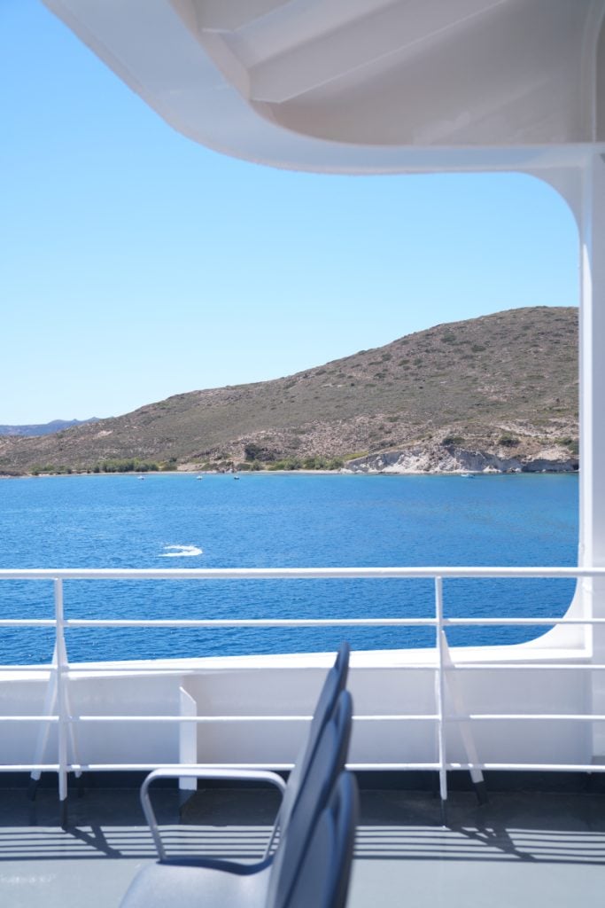 Rocky Milos coastline viewed from a ferry deck