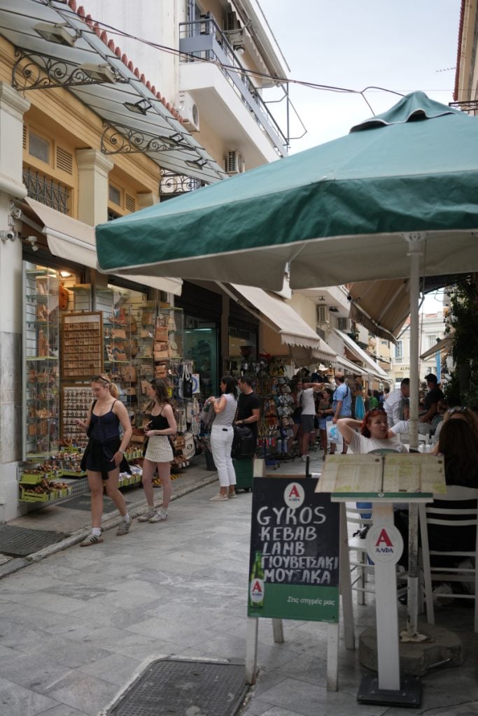 Shoppers and sidewalk restaurant on a Monastiraki street
